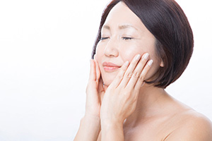 頬に両手を添える女性